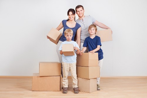 Professional movers carrying furniture from a Forestdale property